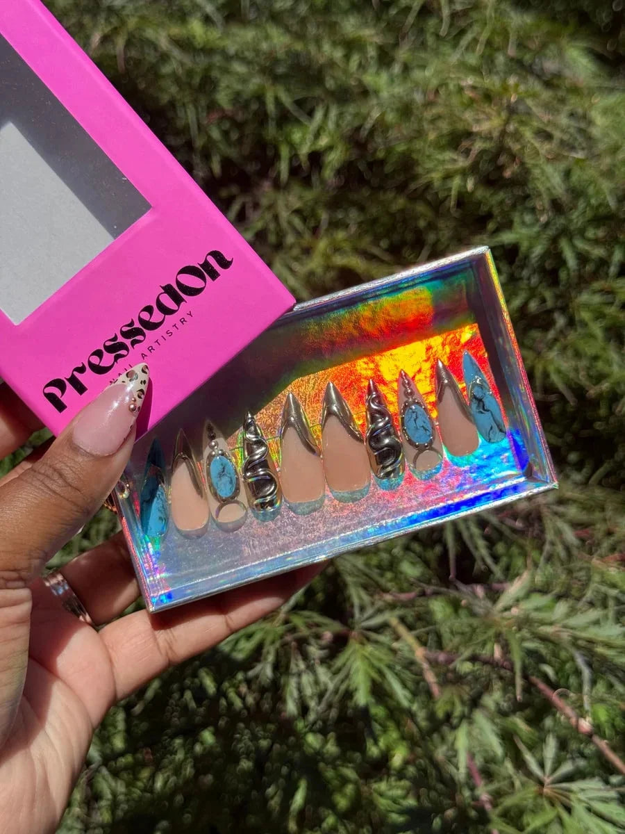 Set of press-on nails with a nude base, gold accents, blue 'croc' style 3D textures, 3D chrome snake embellishments and turquoise stones. Includes almond and stiletto nail shapes.