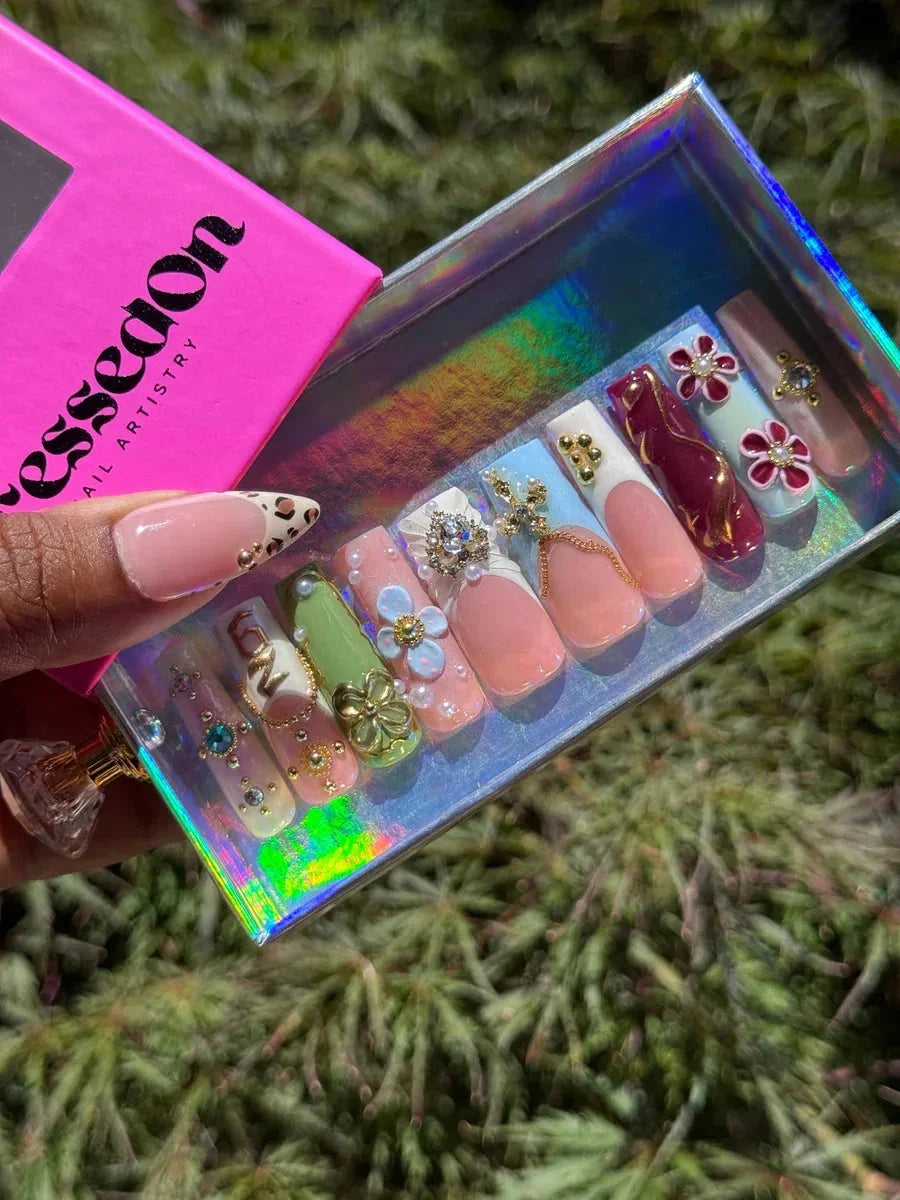 Medium press-on nails featuring a mix of designs including leopard print, 3D flowers, and French tips. The nails have a glossy finish.