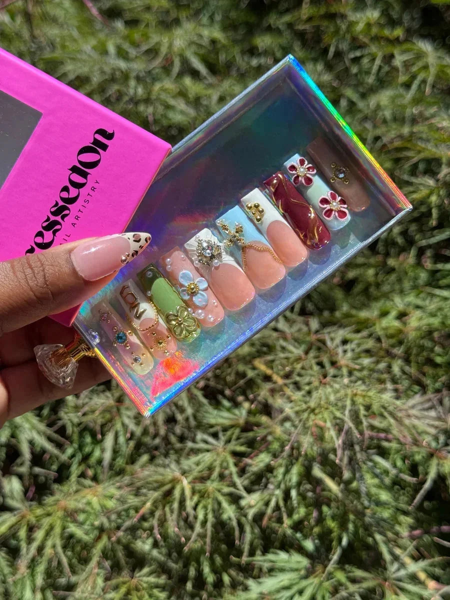 Set of medium press-on nails featuring a 90s vibe with 3D floral designs, leopard print accent nail, and classic French tips. The set showcases glossy fake nails with unique, eye-catching embellishments.