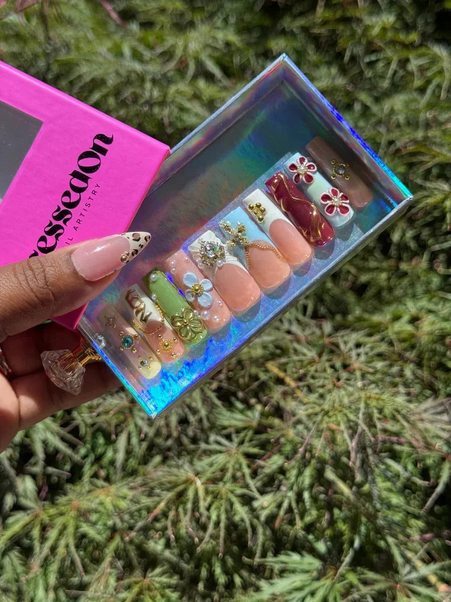 Medium-length press-on nails with French tips, floral designs, and a leopard print accent nail. These nails have 3D embellishments and a glossy finish.