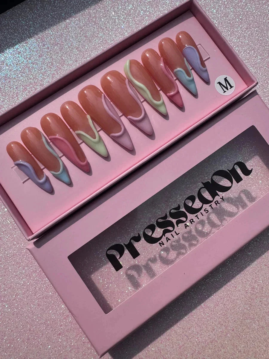 Long stiletto press-on nails with a 3D swirl design in pastel lavender, mint, and pink hues.