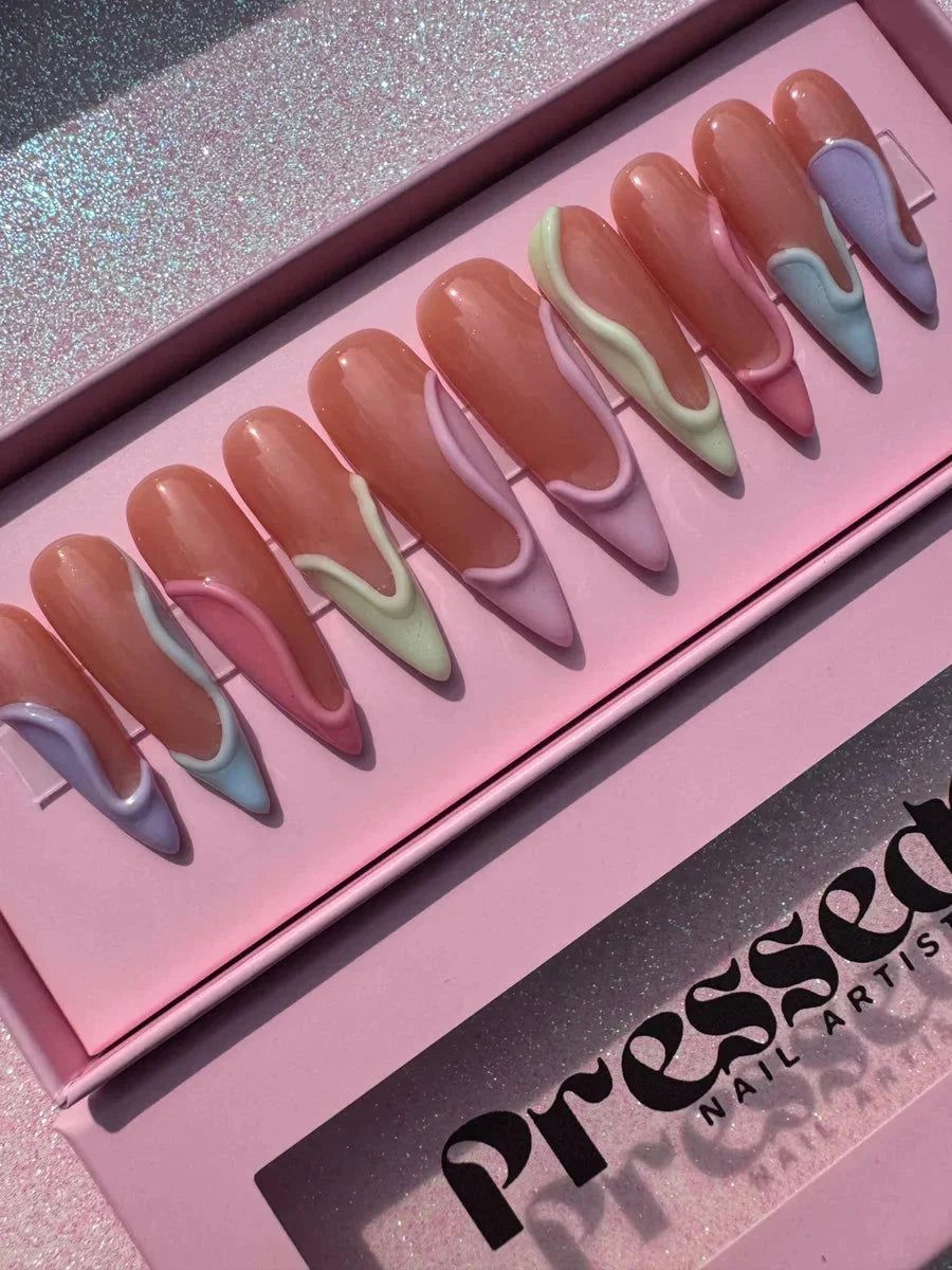 Long stiletto press-on nails feature a glossy finish and 3D pastel swirls in lavender, mint, light blue and pink shades.