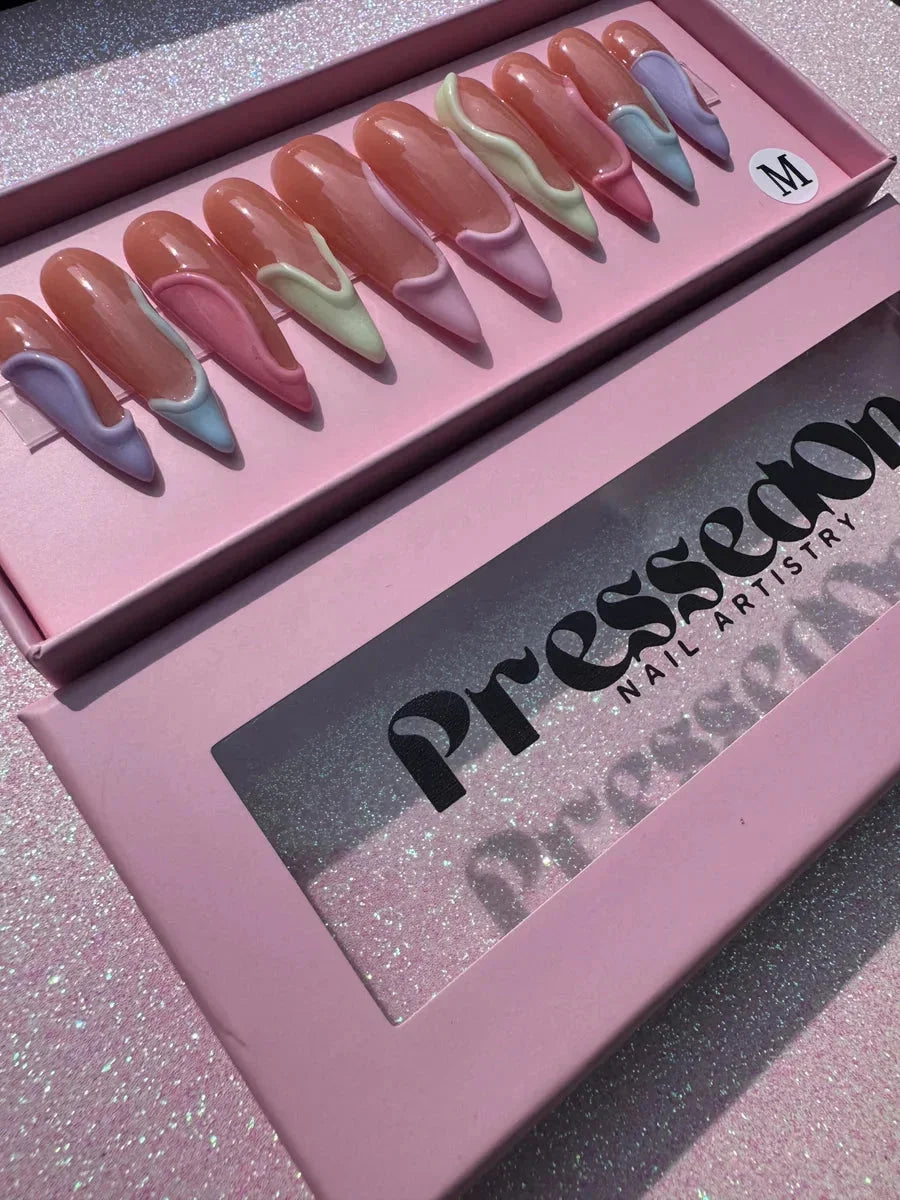 Long stiletto press-on nails with a 3D swirl design in pastel lavender, mint, pink and blue.