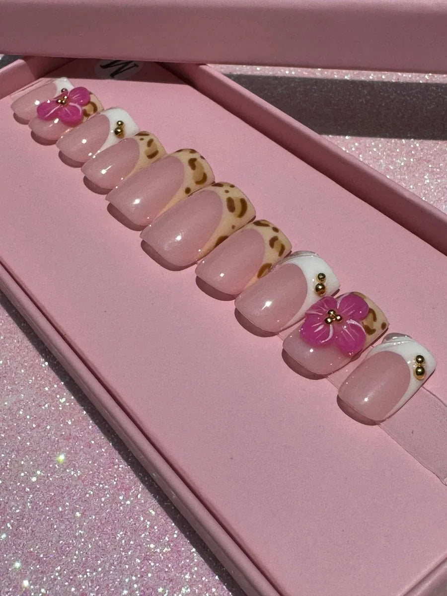 Super short press-on nails with cheetah print and French tips, decorated with gold beads and 3D pink flowers.