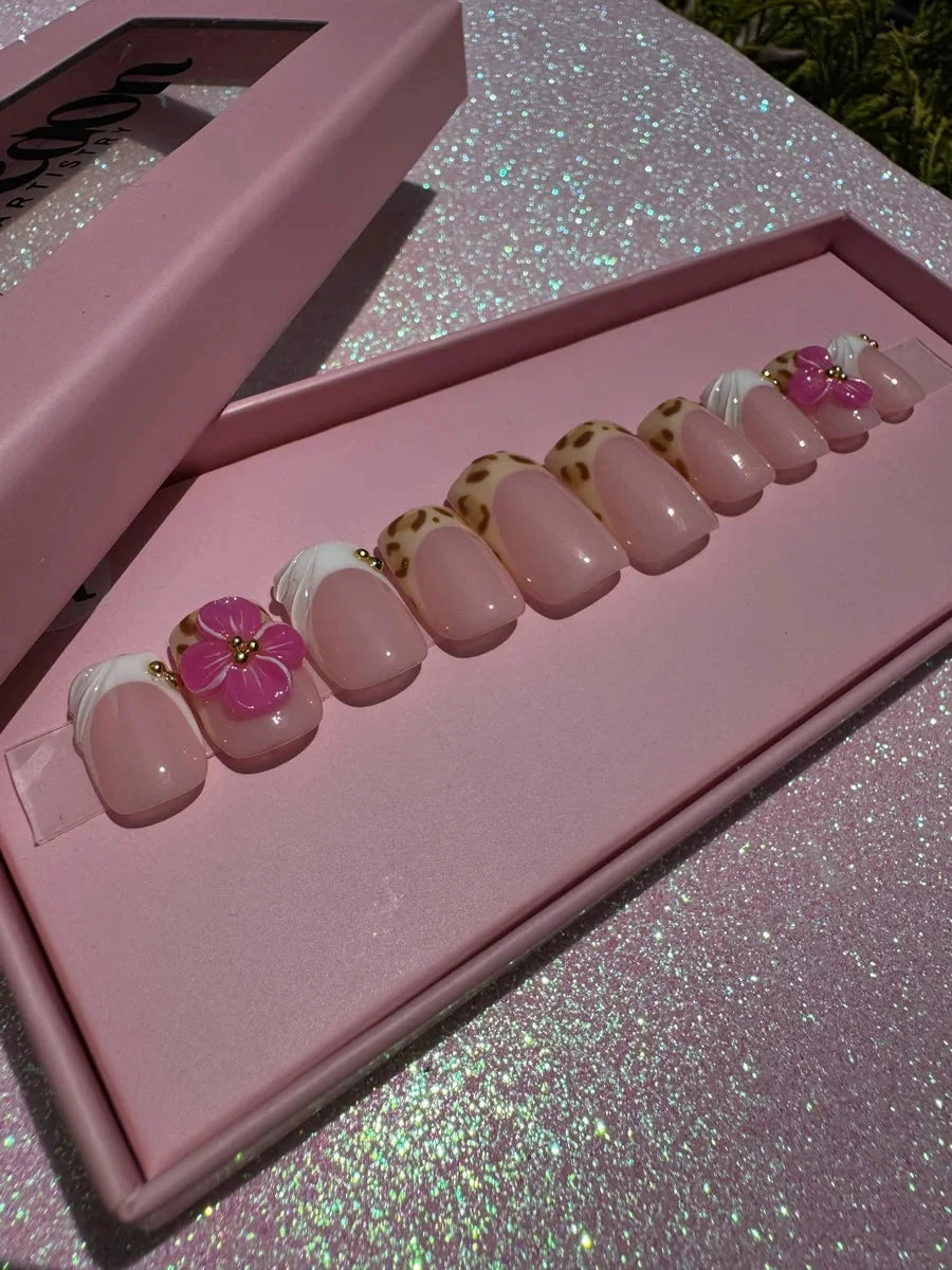 Super short press-on nails with cheetah print and French tip design. Some nails feature pink 3D flower accents and gold embellishments.