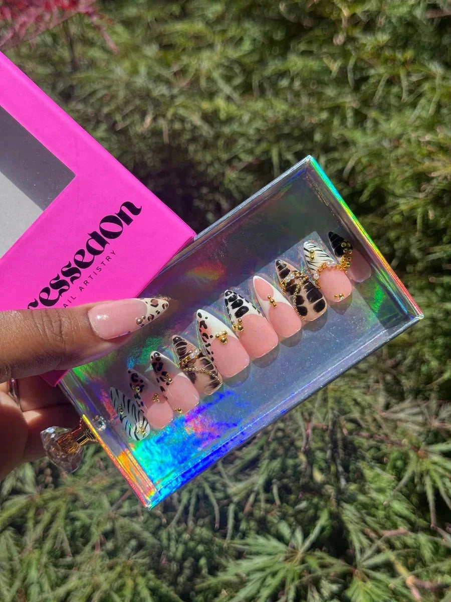 Set of short press-on nails featuring animal prints like leopard and zebra, enhanced with gold accents.