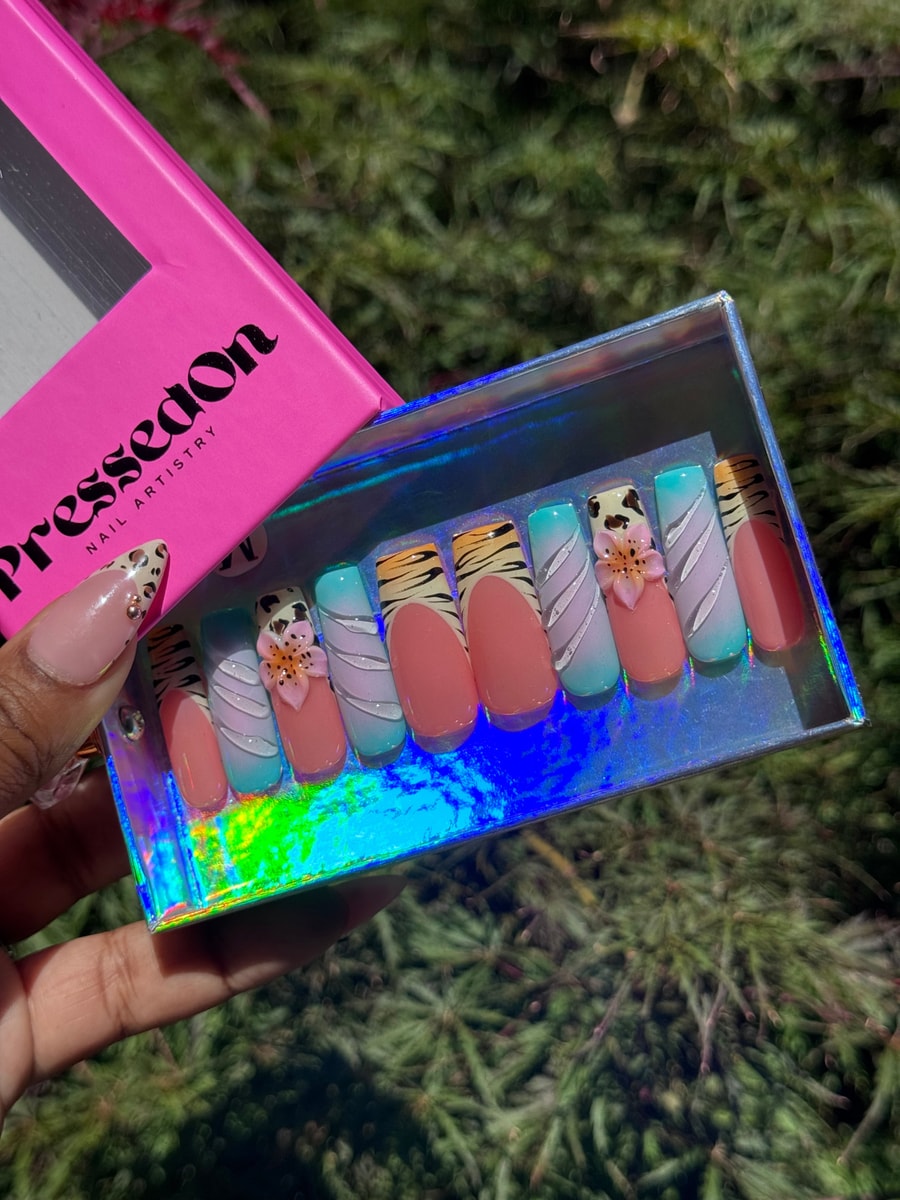 This set of press-on nails has a cheetah print, zebra stripes, a pink base, and a blue gradient. Some nails also have a 3D flower.