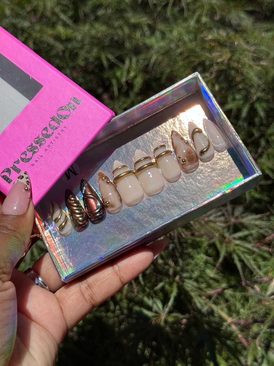 Short press-on nails featuring chrome and neutral color schemes with gold details.