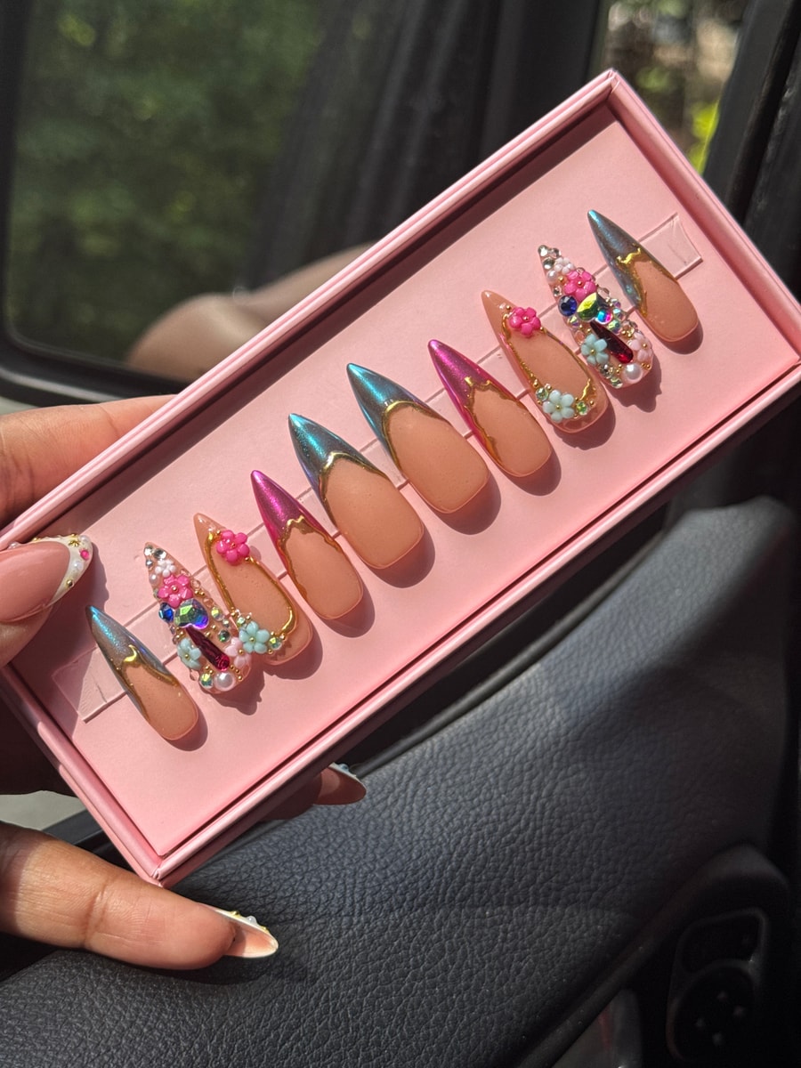 Set of medium press-on nails featuring chrome accents and various gem designs. The set includes pink chrome, blue chrome, flower, and pearl adorned nails.