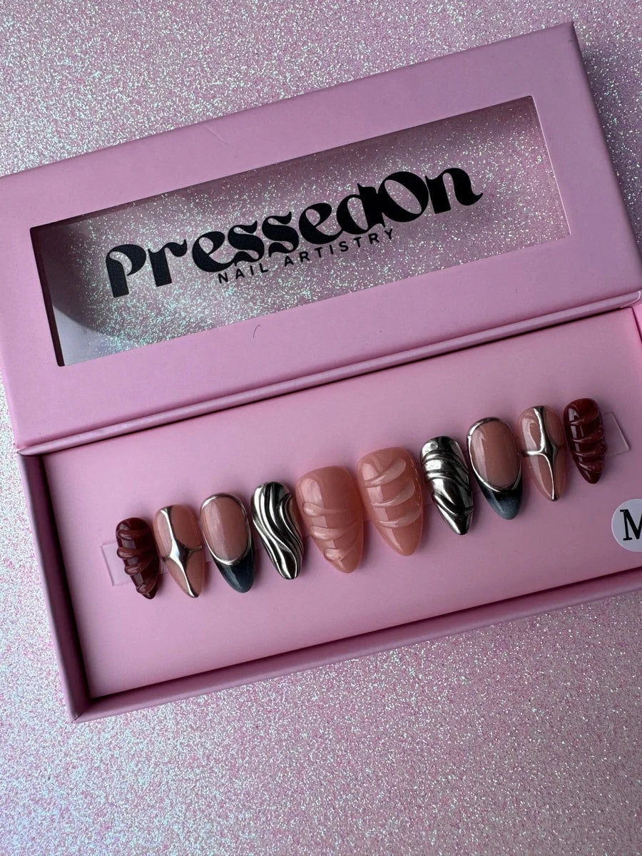 Super short press-on nails with nude and chrome accents, featuring nude tones, metallic silver chrome designs, and sculpted 3D details in brown and nude.