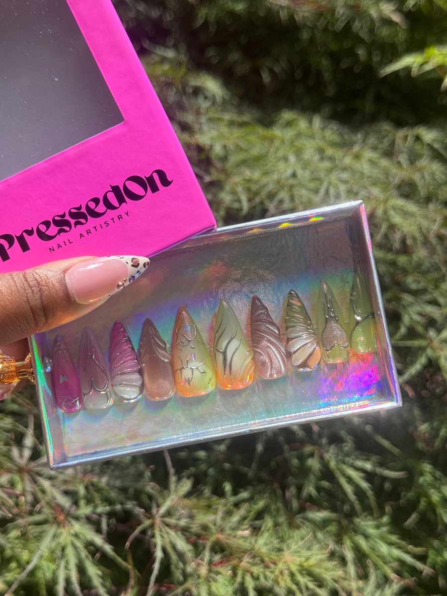 This is a set of medium press-on nails featuring iced, translucent designs in pink, orange, green and brown.