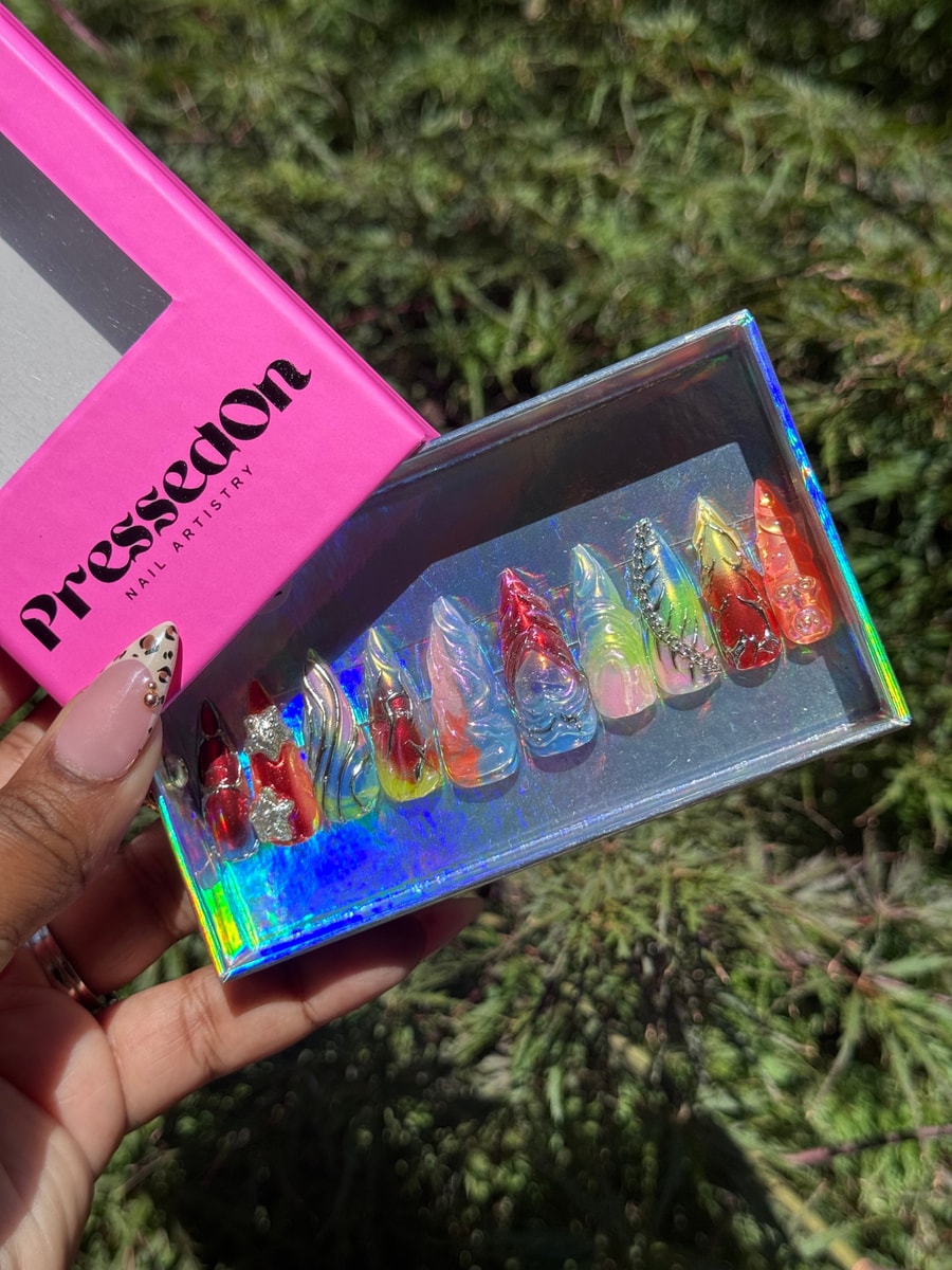 Assorted medium-length press-on nails with an iced junkie theme, with a variety of colors and embellishments including rhinestones and charms.