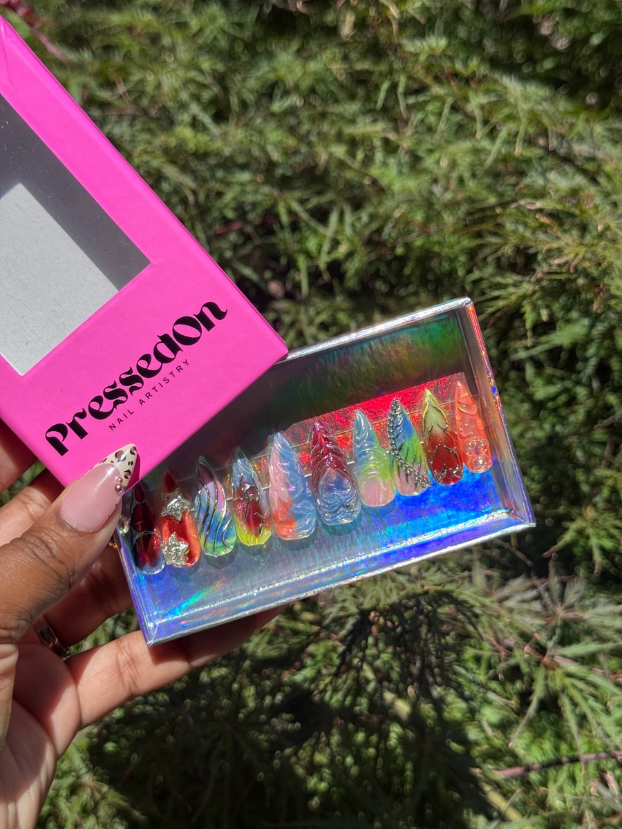 Set of medium-length press-on nails featuring iced accents and colorful abstract designs.