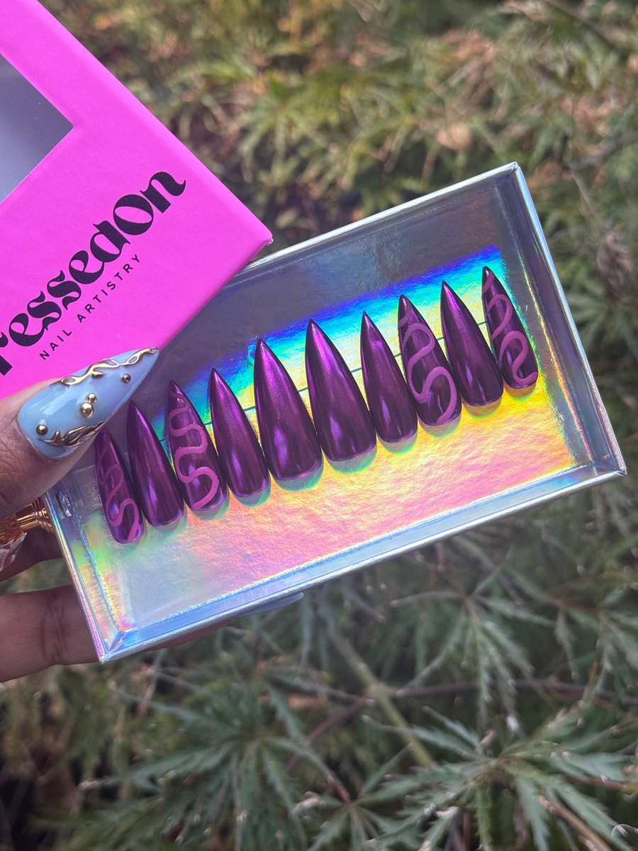 Magenta stiletto press-on nails feature a snake design. These short nails have a metallic finish.