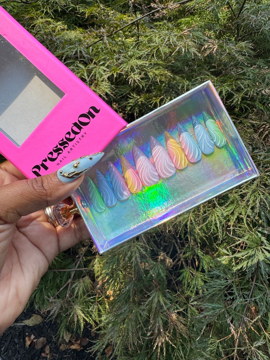 Set of short, stiletto-shaped press-on nails with a 3D swirl design. The nails are pastel shades of pink, yellow, blue, and green.