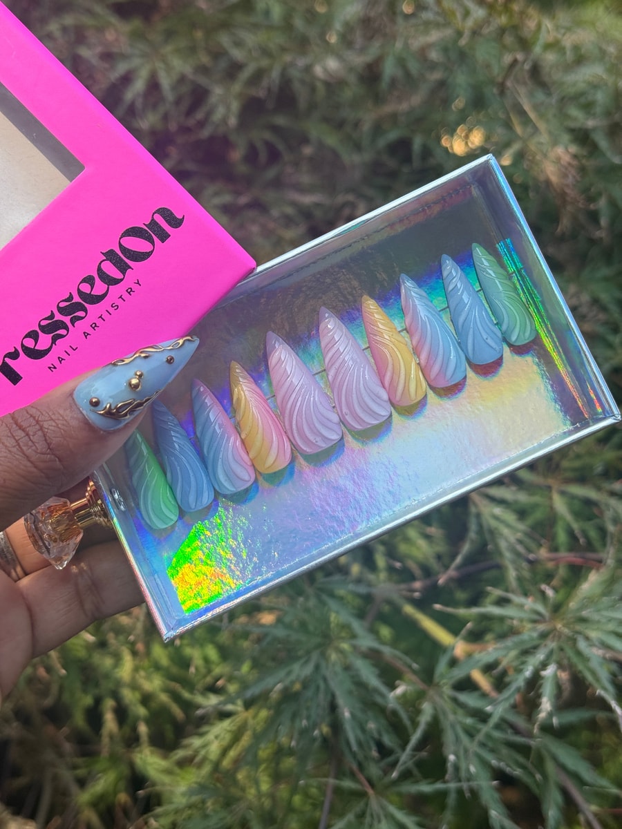 Set of short, multi-colored stiletto press-on nails featuring a 3D uni wave design in pastel shades.