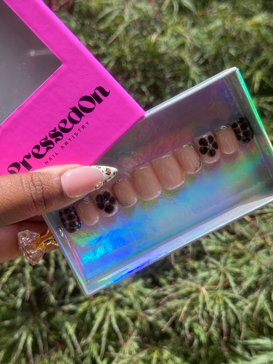 This set features super short press-on nails in nude with black flower designs, silver glitter accents, and dark leopard print nails.