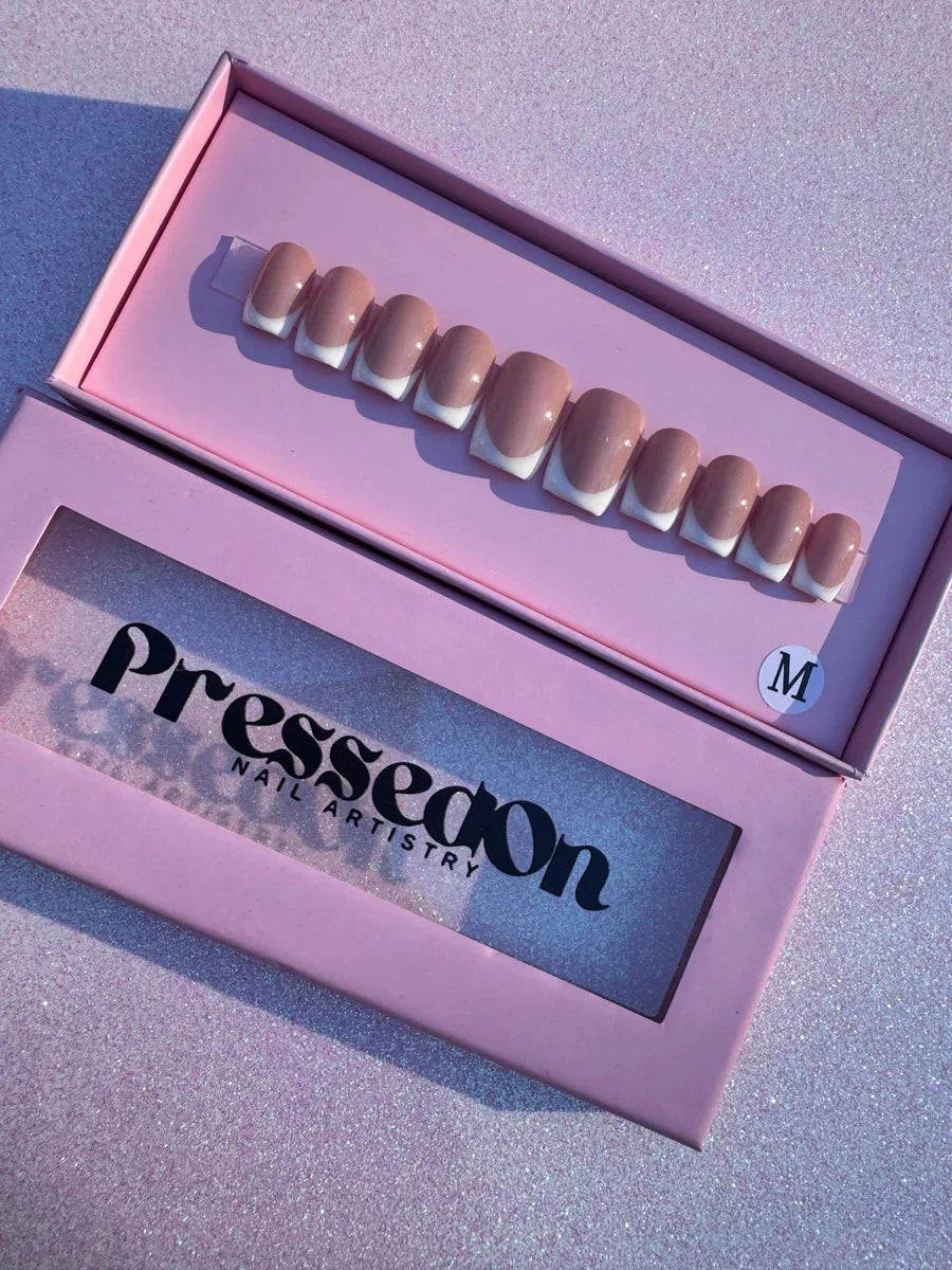 Super short press-on nails with a nude base and white French tips.