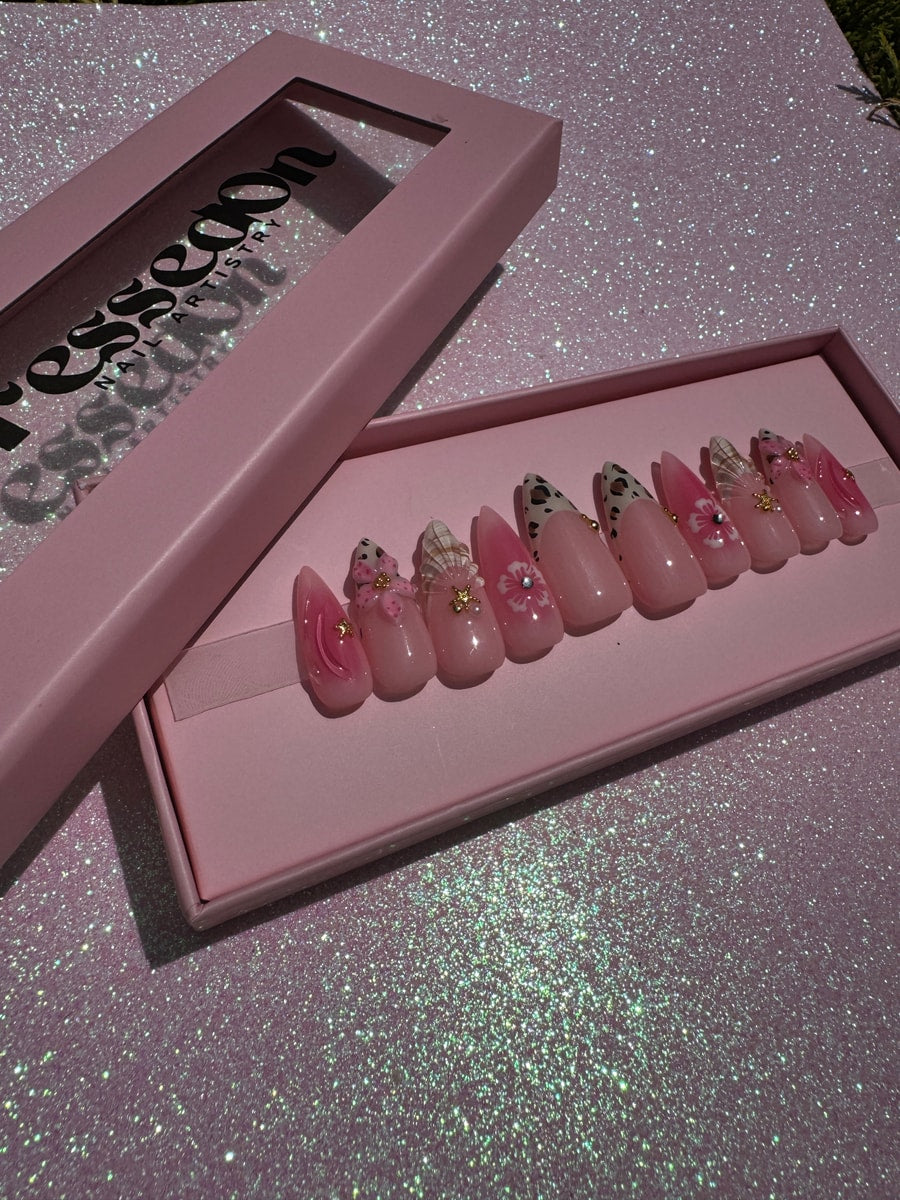 Set of pink press-on nails with cheetah print tips and flower decorations.