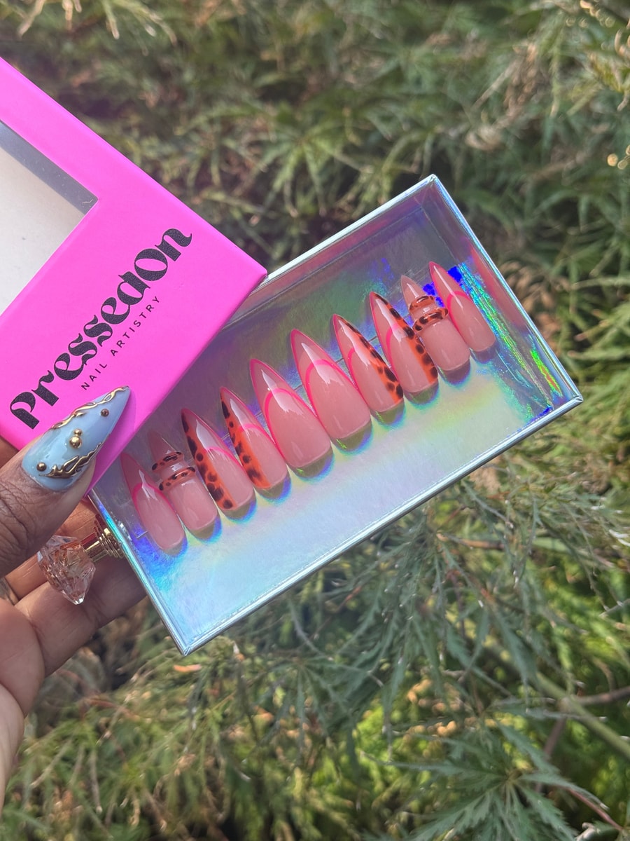 Short, stiletto-shaped press-on nails featuring a pink nude base with neon pink french tips and leopard print designs.