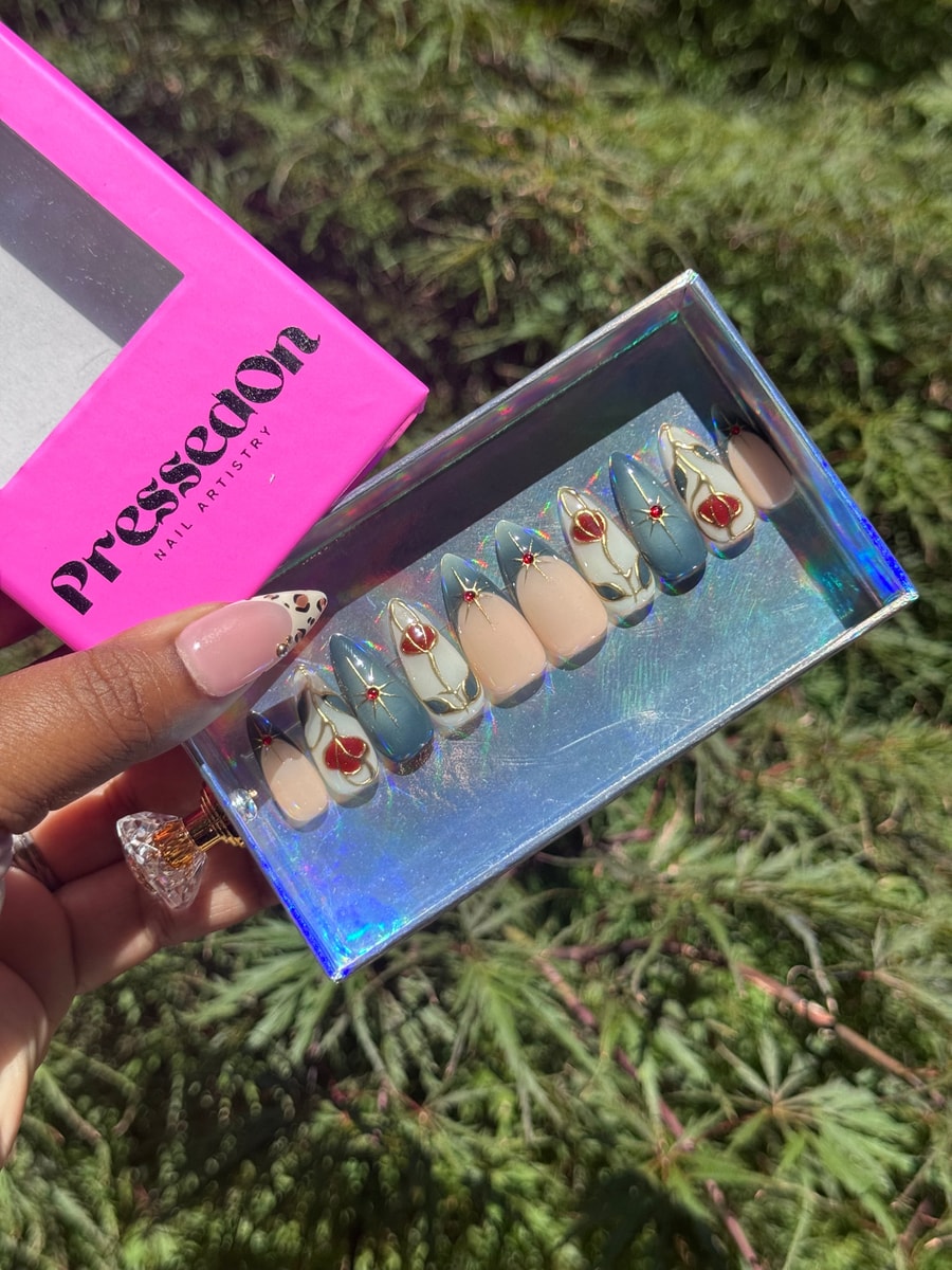 Set of short press-on nails featuring a nude, blue, and white design with tulip accents and red gems.