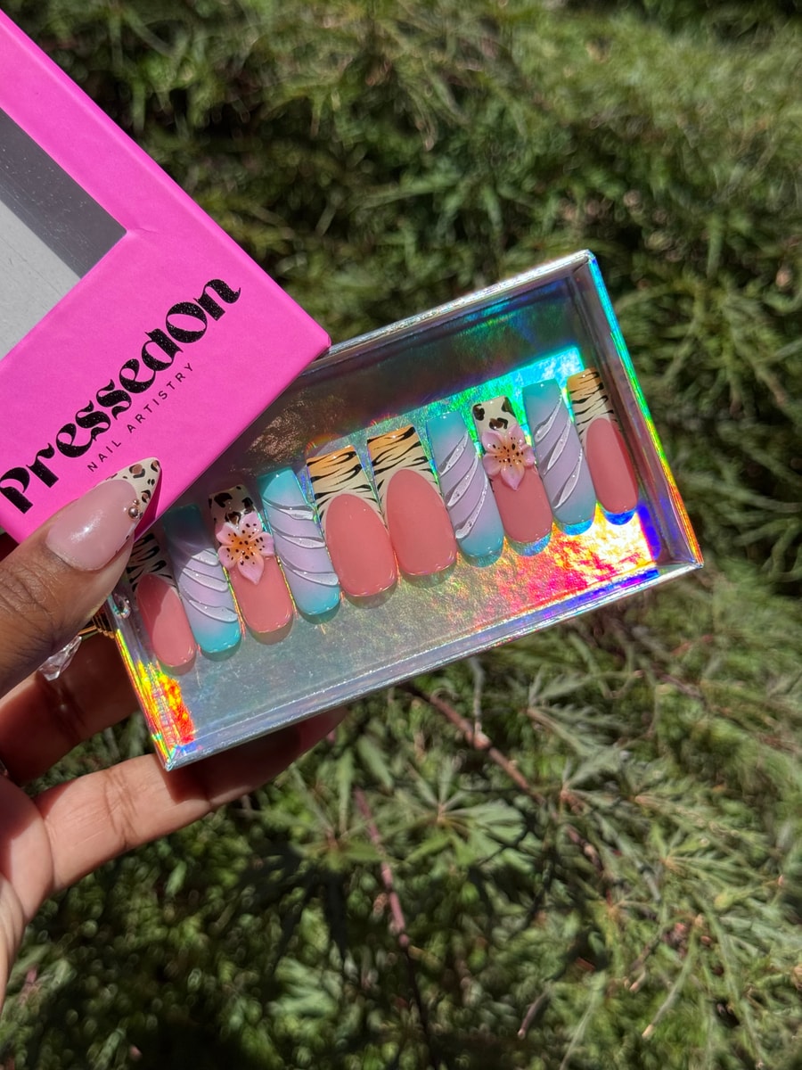 Medium-length press-on nails featuring zebra, cheetah, and tiger print designs with 3D flower embellishments.